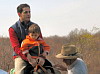 Tuna rides the horse with dad.